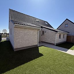 Stijlvolle eetkamer in vakantiehuis Westhinder II H23, Koksijde, West-Vlaanderen met moderne keuken en houten plafond.