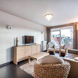 Stijlvolle woonkamer van Le Penthouse vakantiehuis in Koksijde, West-Vlaanderen, met comfortabele zithoek en uitzicht op de omgeving.