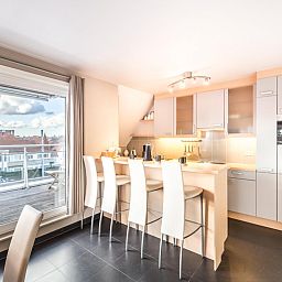 Moderne keuken in Le Penthouse vakantiehuis, Koksijde, West-Vlaanderen met uitzicht op terras en stad.