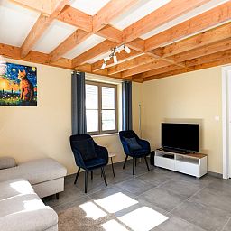 Gezellige woonkamer in vakantiehuis Westhinder II H54, Koksijde, Belgie met comfortabele zithoek en moderne inrichting.