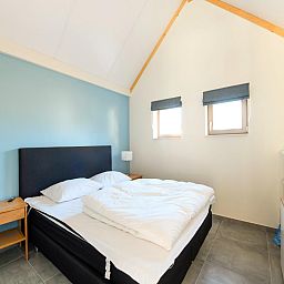 Gezellige slaapkamer in vakantiehuis Westhinder II H54, Koksijde, met comfortabel bed en veel natuurlijk licht.