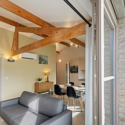 Moderne woonkamer van vakantiehuis Westhinder II H18 in Koksijde, West-Vlaanderen, met ruime zithoek en veel natuurlijk licht.