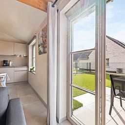 Moderne keuken en eetruimte in vakantiehuis Westhinder II H18, Koksijde, West-Vlaanderen, met veel lichtinval en stijlvolle inrichting.