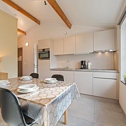 Gezellige woonkamer in vakantiehuis Westhinder II H18, Koksijde, met comfortabele bank en moderne inrichting, ideaal voor ontspanning in West-Vlaanderen.