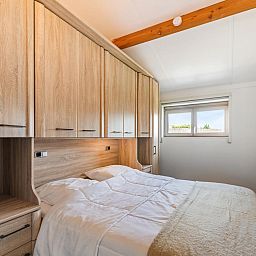 Gemuetliches Wohnzimmer des Ferienhauses Westhinder II H19 in Koksijde, Westflandern, mit bequemem Sofa und moderner Kueche.