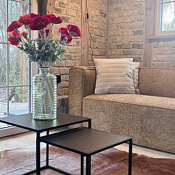 Cozy living room of Cottage in Alveringem, vacation home in West Flanders, with wood stove and television for ultimate relaxation.