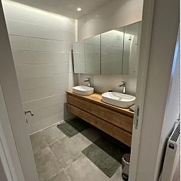 Moderne Kueche in der Wohnung Memling, Sint-Andries, Westflandern, mit schlichtem Design und attraktiver Backsteinwand.