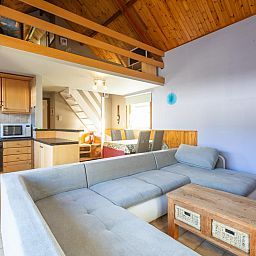 Gezellige woonkamer in vakantiehuis Wittedorp - 15, Lombardsijde, West-Vlaanderen met houten interieur en comfortabele zithoek.