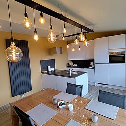 Stilvolle Kueche des Cottage in Ingooigem, Ferienhaus in Belgien, mit modernen Geraeten und stimmungsvoller Beleuchtung.