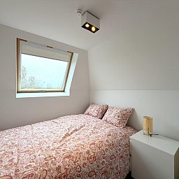 Gemuetliches Schlafzimmer im Ferienhaus Home Sweet Home, De Panne, Westflandern, mit bequemem Bett und viel Tageslicht.