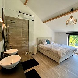 Luxurioeses Schlafzimmer im Ferienhaus Petunias Deluxe, Sint-Idesbald, Westflandern, mit moderner Einrichtung und Gartenblick.