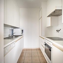 Moderne keuken in vakantiehuis Cat Tweede, Sint-Idesbald, West-Vlaanderen, met strakke witte kasten en volledige uitrusting.
