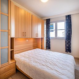 Gezellige slaapkamer in vakantiehuis Cat Tweede, Sint-Idesbald, West-Vlaanderen met houten kasten en natuurlijk licht.