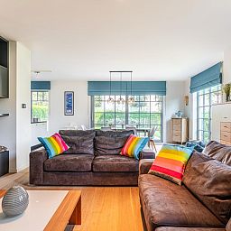 Gezellige woonkamer van vakantiehuis La Matinee in Sint-Idesbald, West-Vlaanderen, met comfortabele zitplaatsen en veel natuurlijk licht.