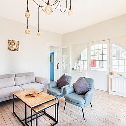 Stijlvolle woonkamer van La Classe vakantiehuis in Sint-Idesbald, West-Vlaanderen, Belgie met comfortabele zitruimte en veel natuurlijk licht.