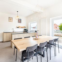 Moderne keuken en eetruimte in vakantiehuis La Classe, Sint-Idesbald, West-Vlaanderen met uitzicht op terras en tuin.