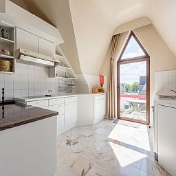 Lichte keuken van vakantiehuis Aubepine troisieme in Sint-Idesbald, West-Vlaanderen, met moderne inrichting en uitzicht op de omgeving.