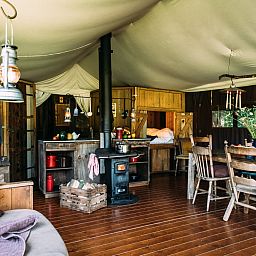 Gezellige binnenruimte van Tenthuisje met warme privedouche in Zedelgem, West-Vlaanderen, Belgie. Geniet van glamping comfort in een rustieke setting.