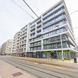 Blick vom Balkon des Ferienhauses Kingston I - 0701 park 3 in Middelkerke, Westflandern, auf die staedtische Umgebung und den Himmel.