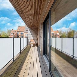 Veranda der Kruiers Eco Lodge in Middelkerke, Westflandern, mit Blick auf die Natur und moderne Architektur.