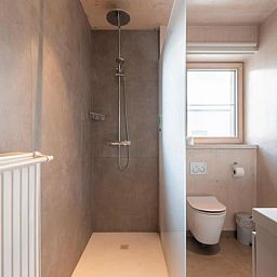 Modernes Badezimmer in Kruiers Eco Lodge, einem Ferienhaus in Middelkerke, Westflandern, mit geraeumiger Dusche und natuerlichem Licht.