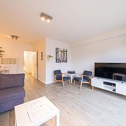Modernes Wohnzimmer im Ferienhaus Scholekster - 0004 in Middelkerke, Westflandern, mit gemuetlicher Sitzecke und Flachbildfernseher.