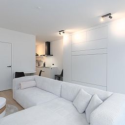 Stilvolles Wohnzimmer im Ferienhaus Omnia 7 - 0103 + Park. 5 in Middelkerke, Westflandern, mit moderner Einrichtung und gemuetlicher Sitzecke.