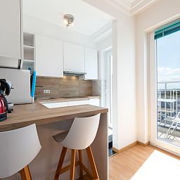 Moderne Kueche im Ferienhaus "Sunflower - 0705" in Middelkerke, mit viel Licht und Blick auf den Balkon in Westflandern, Belgien.