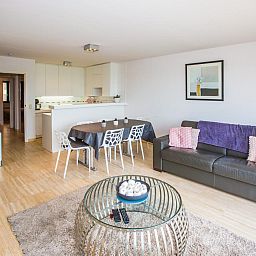 Stilvolles Wohnzimmer des Ferienhauses "Escale II - 0201" in Middelkerke, Westflandern, mit moderner Einrichtung und offener Kueche.