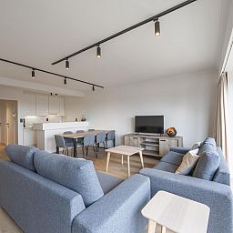 Geraeumiges Wohnzimmer des Ferienhauses "Harmony - 0301" in Middelkerke, Westflandern, mit moderner Einrichtung und Blick auf die Terrasse.