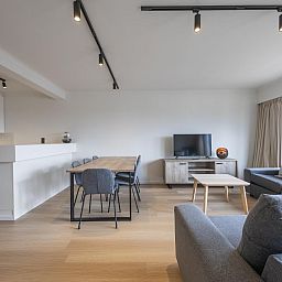 Modernes Wohnzimmer im Ferienhaus Harmony - 0301, Middelkerke, Westflandern, mit gemuetlicher Sitzecke und Essbereich.