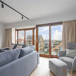 Gemuetliches Wohnzimmer im Ferienhaus "Harmony - 0301" in Middelkerke, Belgien, mit Blick auf die Stadt und viel Tageslicht.