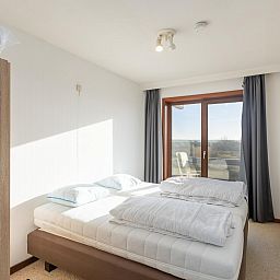 Helles Schlafzimmer in Dunekant - 0203 + park.6, Ferienhaus in Middelkerke, Belgien mit Blick auf die Terrasse und die Natur.