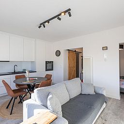 Modernes Wohnzimmer und Kueche im Ferienhaus Hawaii - 0003, Middelkerke, Belgien, mit komfortabler Einrichtung und viel Tageslicht.