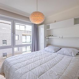 Helles Schlafzimmer im Ferienhaus Kwintebank - 0904 in Middelkerke, Westflandern, Belgien mit grossem Fenster und bequemem Doppelbett.