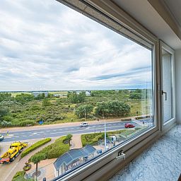 Blick vom Ferienhaus Majestic - 0505 in Middelkerke, Westflandern mit gruener Umgebung und Meer am Horizont.