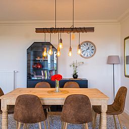 Stilvolle Essecke im Ferienhaus Majestic - 0505, Middelkerke, Westflandern mit Holztisch und moderner Beleuchtung.