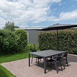 Geniessen Sie den Platz im Freien in der Access Lodge in Westende, Westflandern, Belgien, mit einer gemuetlichen Terrasse und einer gruenen Umgebung.