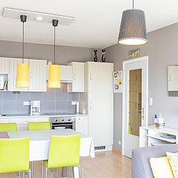 Moderne keuken en eetruimte in vakantiehuis Con Amore - 0403, Westende, Belgie, met stijlvolle inrichting en comfortabele zitplaatsen.