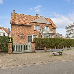 Maison Edith, een charmant vakantiehuis in Westende, West-Vlaanderen, biedt een gastvrije buitenkant met rode bakstenen en een zonnig terras.