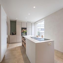 Moderne keuken van Maison Edith, vakantiehuis in Westende, West-Vlaanderen, Belgie, met ruime kookeiland en veel natuurlijk licht.