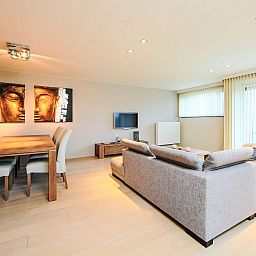 Moderne woonkamer van Appartement Cocoon in Bredene, West-Vlaanderen, met comfortabele zithoek en eethoek voor een ontspannen verblijf.