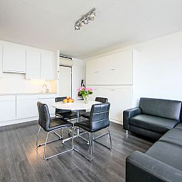 Helles Wohnzimmer des Apartment Studios mit Garage in Bredene, Westflandern, Belgien, mit moderner Kueche und gemuetlicher Sitzecke.