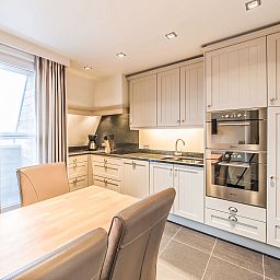 Moderne Kueche im Apartment Duplex, Bredene, Westflandern, mit stilvollem Dekor und viel natuerlichem Licht.