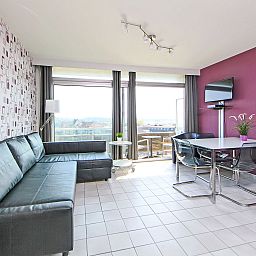 Stilvolles Wohnzimmer des Apartment Studio 604 in Bredene, Belgien, mit moderner Einrichtung und Blick auf die Terrasse und die Umgebung.