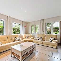 Gezellige woonkamer van vakantiehuis Frontzate in Diksmuide, West-Vlaanderen met comfortabele banken en veel natuurlijk licht.