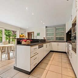 Gezellige eetkamer in vakantiehuis Frontzate te Diksmuide, West-Vlaanderen, met elegant gedekte tafel en uitzicht op de groene omgeving.