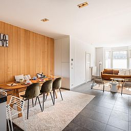 Stilvoller Innenbereich des Ferienhauses "Magique 31" in Oostduinkerke, Belgien, mit modernem Ess- und Sitzbereich.
