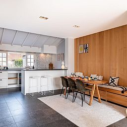 Stilvoller Innenbereich des Ferienhauses "Magique 31" in Oostduinkerke, Belgien, mit moderner Kueche und gemuetlichem Essbereich.