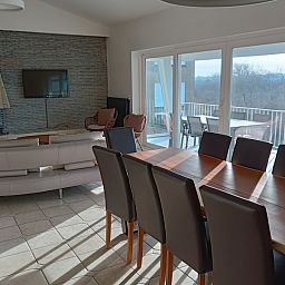Cozy living room in Papa's Dream vacation home, Oostduinkerke, with large dining table and view of terrace.